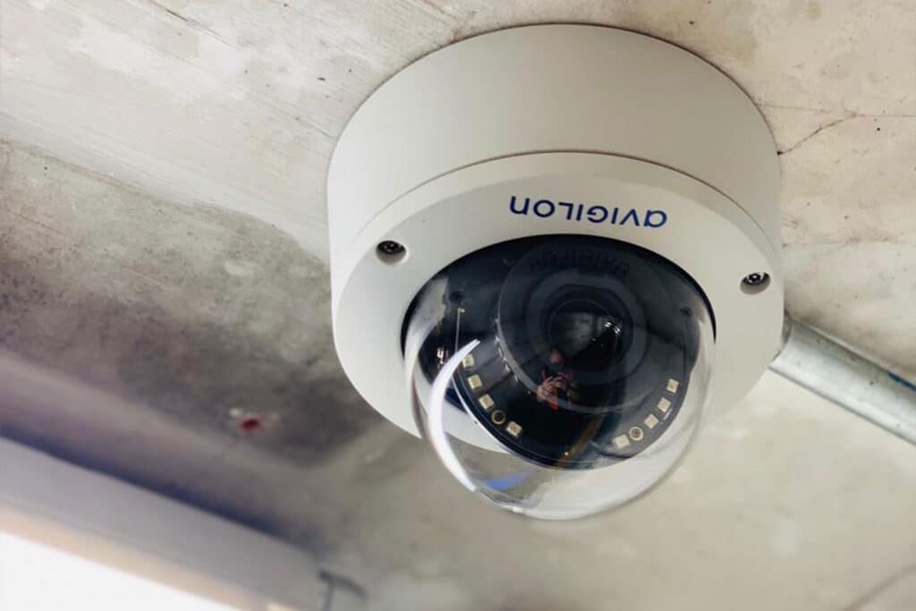 Close-up of a white Univision dome CCTV camera mounted on a concrete ceiling with visible lens and infrared LEDs